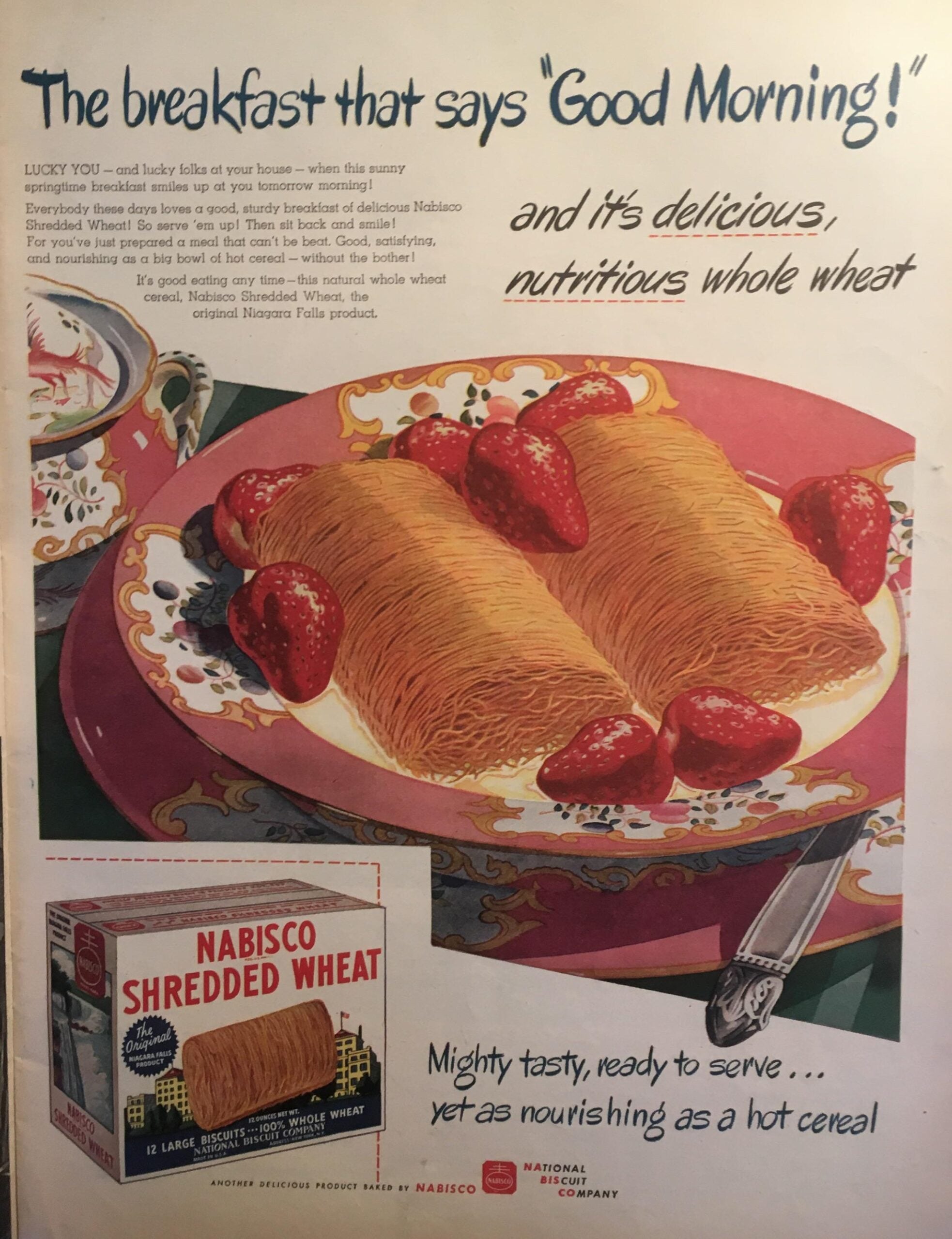 A colorful vintage ad shows two Shredded Wheat biscuits topped with strawberries on a plate. A box of Nabisco Shredded Wheat sits in the corner, with text promoting its taste, nutrition, and convenience.