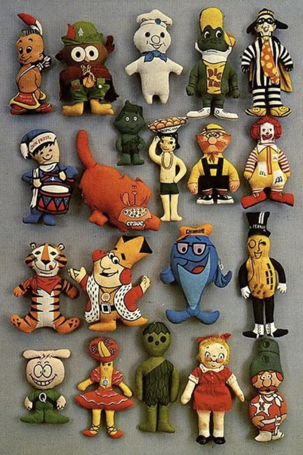 Twenty colorful vintage fast-food and snack brand character plush toys are arranged in a 5x4 grid on a neutral background, featuring mascots like a tiger, peanut, and clown in various costumes and poses.