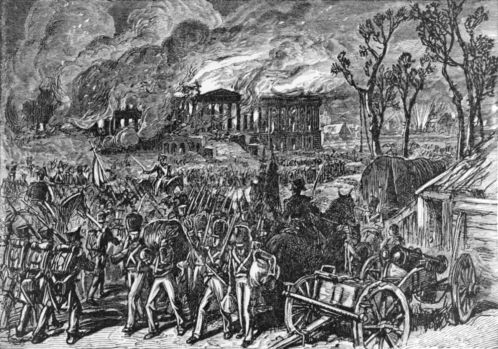 Soldiers march as buildings burn in the background; cannons, smoke, and trees are visible, depicting a chaotic wartime scene with advancing troops and destruction.