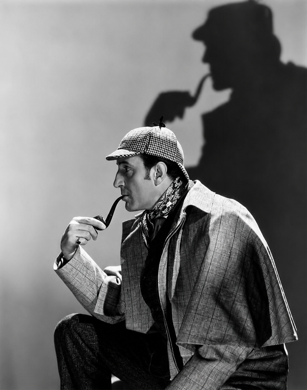 A person in a checkered hat and cape holds a pipe, with their shadow on the wall behind them. The scene evokes a classic detective look, reminiscent of Sherlock Holmes.