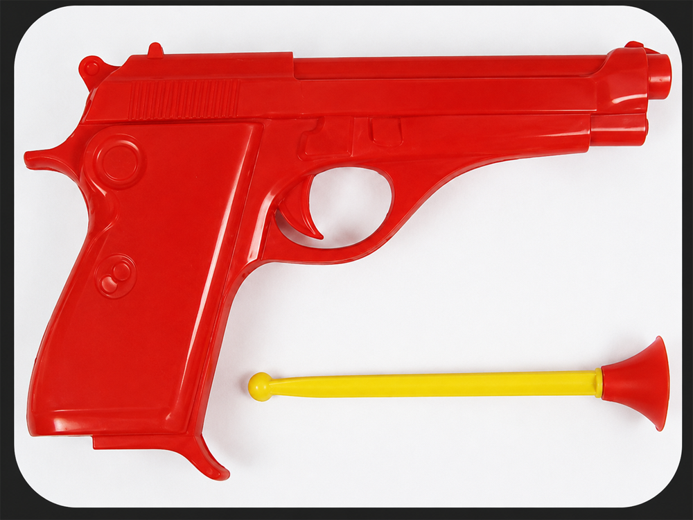 A red plastic toy gun with a yellow suction-cup dart placed below it, both on a white background.
