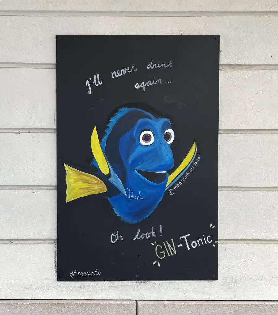 A mural of Dory from Finding Nemo says, “I’ll never drink again... Oh look! GIN-Tonic.” The words are written in playful white text on a black background.