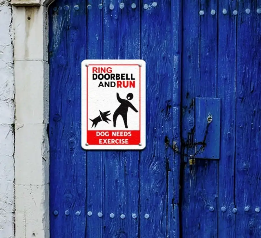 A sign on a blue door reads, “Ring doorbell and run. Dog needs exercise,” with an image of a person being chased by a dog.