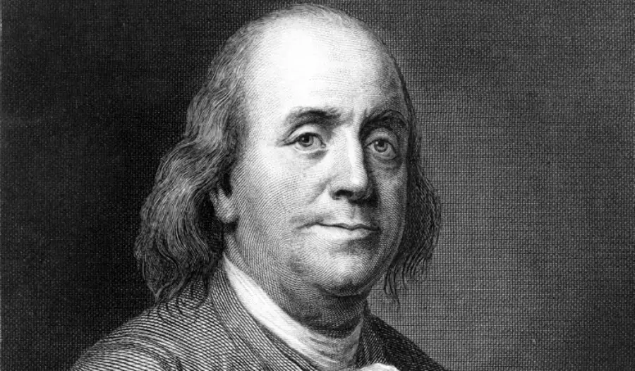 Black and white engraving of an older man with long hair, wearing a coat and cravat, facing slightly to the right with a neutral expression. The background is dark and plain.