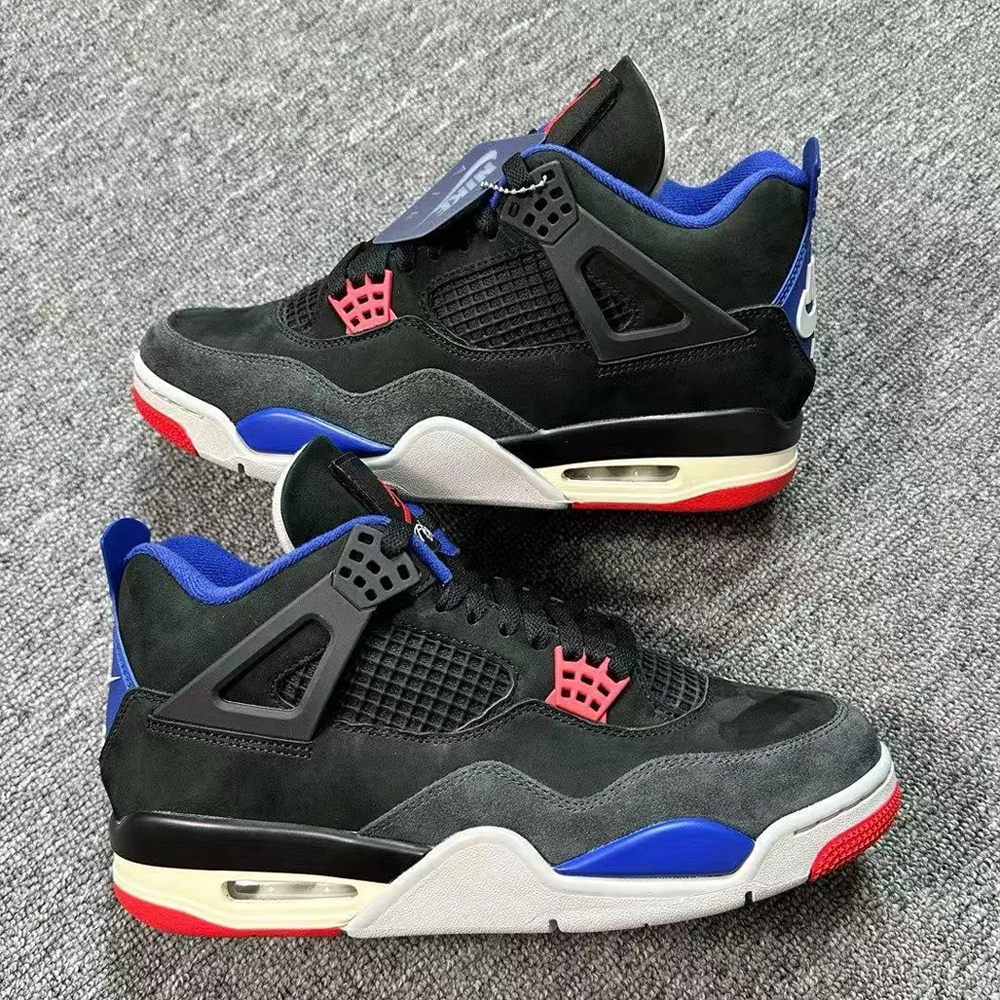 A pair of black, red, blue, and cream sneakers with mesh panels and suede overlays displayed on a gray carpeted surface.