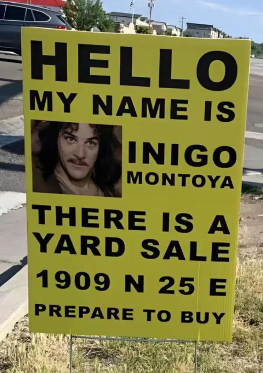 A yellow yard sale sign reads: “HELLO MY NAME IS INIGO MONTOYA. THERE IS A YARD SALE 1909 N 25 E. PREPARE TO BUY,” with a photo of a mustached man.