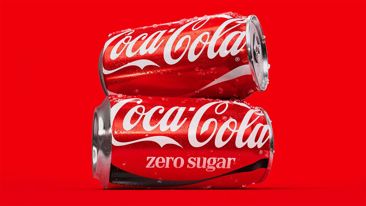 Two cold Coca-Cola cans, one labeled “zero sugar,” stacked on each other with water droplets on a bright red background.