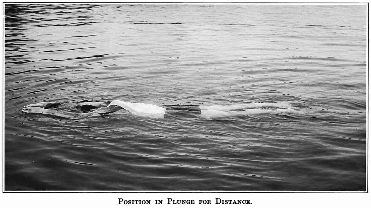 A person floats face down and motionless on the surface of calm water, arms extended forward. The caption below reads, “Position in Plunge for Distance.”