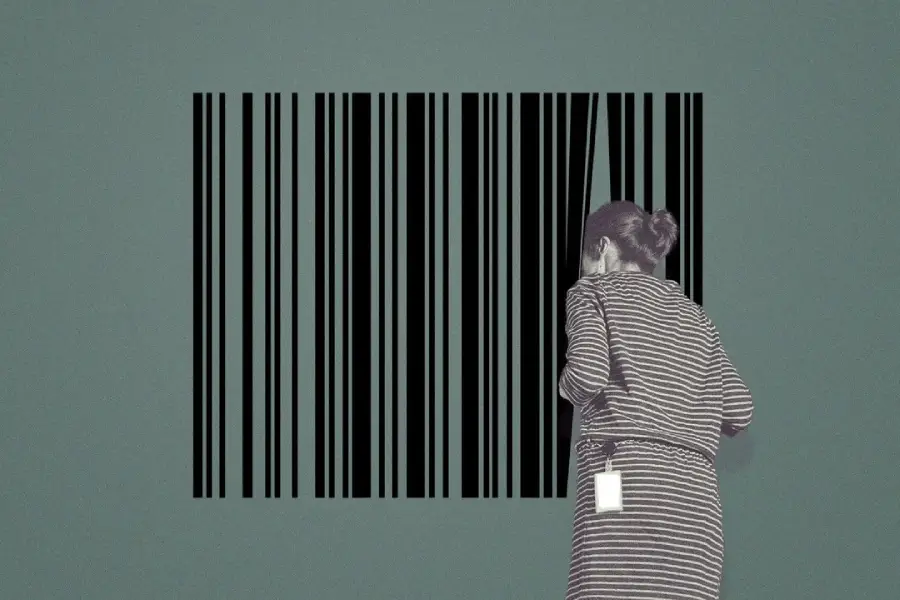 A woman wearing striped clothing stands in front of a large barcode on a green wall, blending in with the black lines.