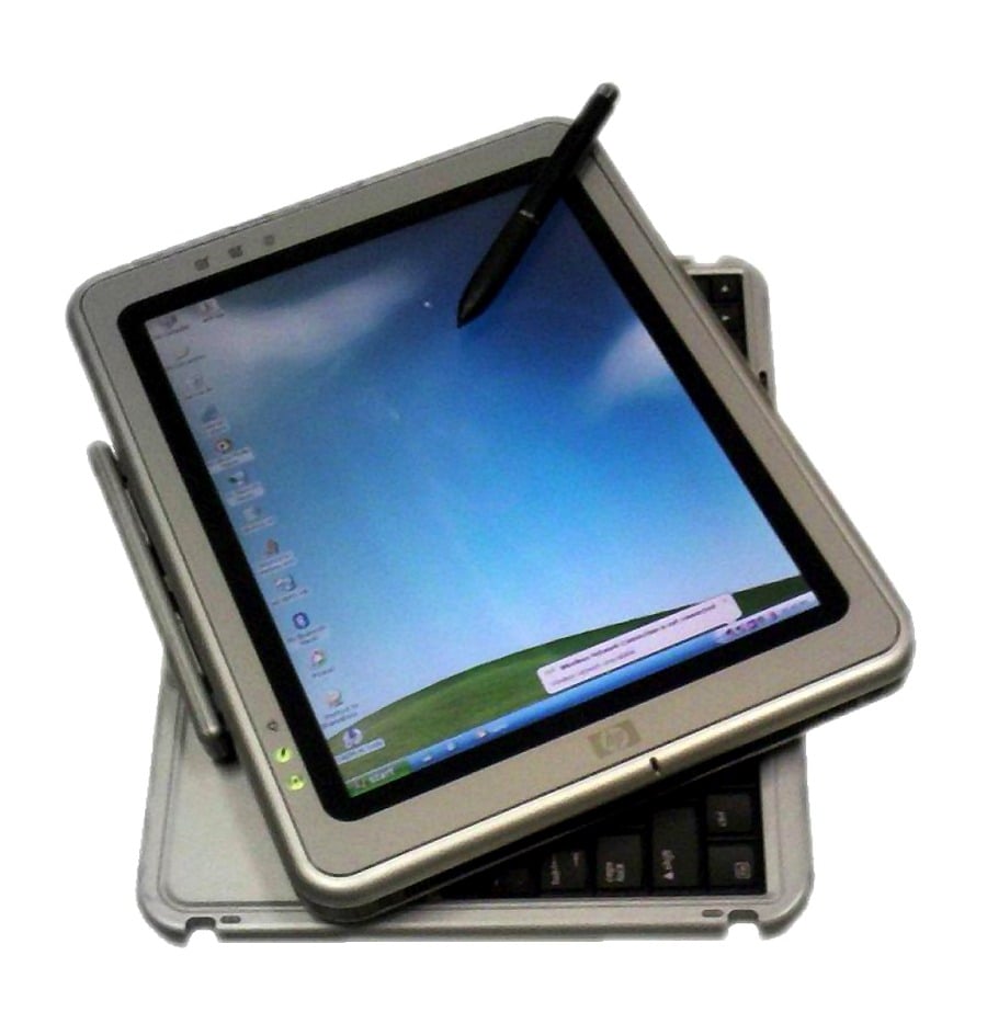 A gray tablet PC with a stylus, showing a desktop screen, is rotated on top of a partially visible keyboard.