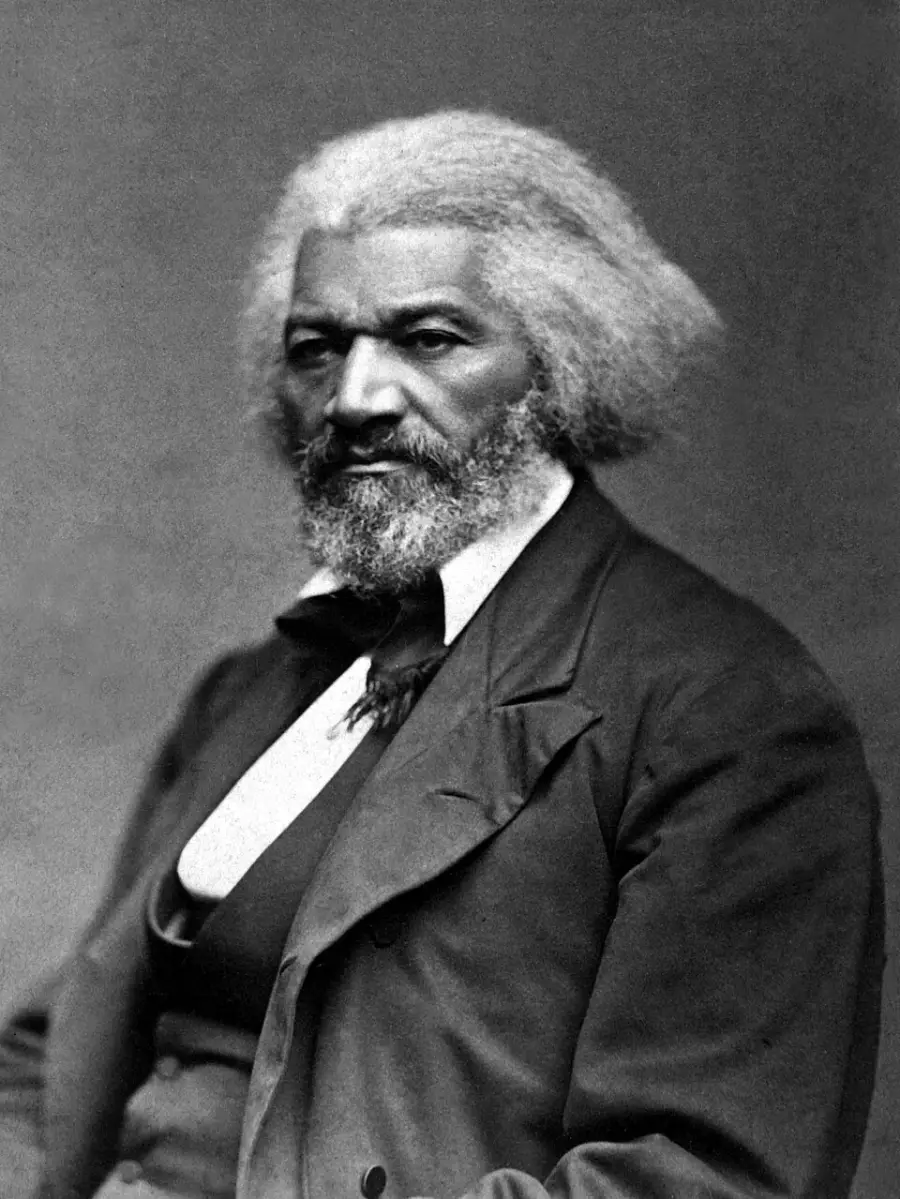 Black and white portrait of an older man with white hair and beard, wearing a suit, waistcoat, bow tie, and seated while looking forward with a serious expression.