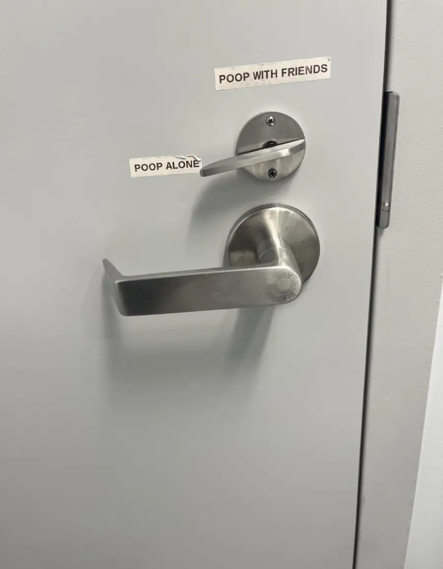 A door with two handles. The top handle is labeled “POOP WITH FRIENDS” and the bottom handle is labeled “POOP ALONE.”