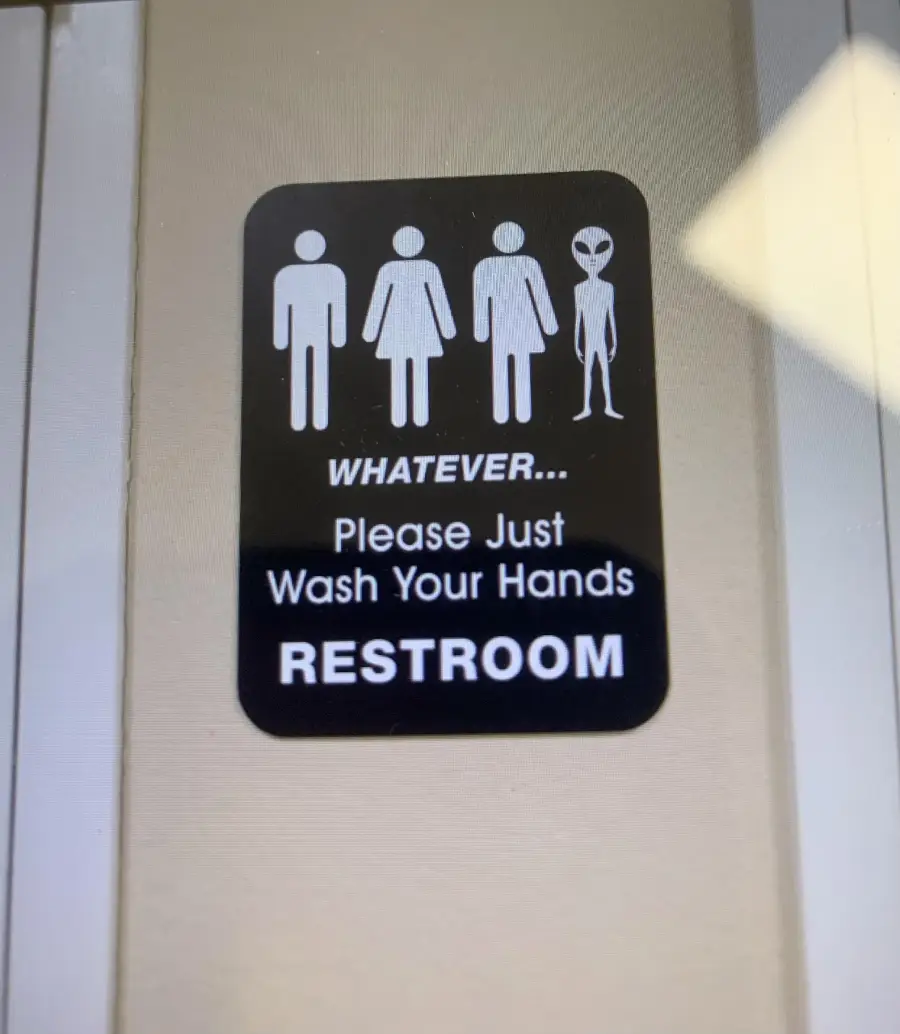 Restroom sign with icons for male, female, and an alien. Text reads: “WHATEVER... Please Just Wash Your Hands RESTROOM.”