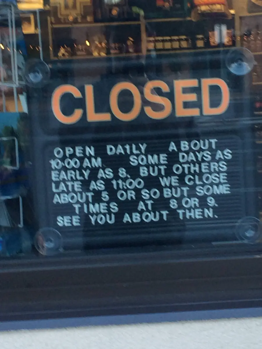 A sign reads: “CLOSED. Open daily about 10 a.m. Some days as early as 8, but others as late as 11. We close about 5 or so but sometimes at 8 or 9. See you about then.”