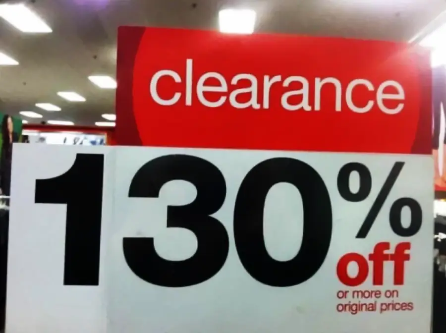 A store sign reads “clearance” with “130% off or more on original prices” in bold black and red text, indicating a humorous or confusing discount.