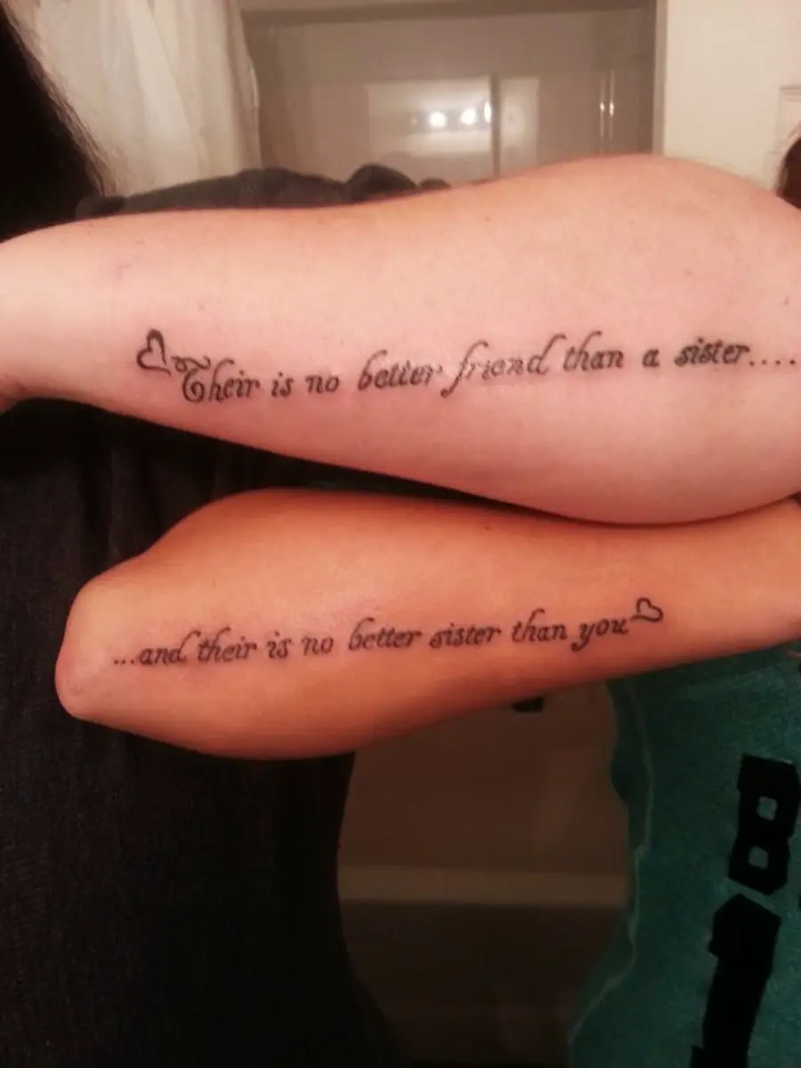 Two forearms with matching tattoos: “Their is no better friend than a sister…” and “…and their is no better sister than you.” Both have small heart designs.