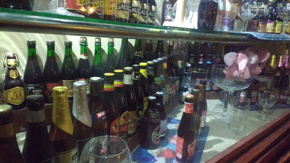A variety of beer bottles displayed on glass shelves.