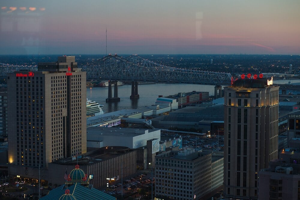 Cityscape of New Orleans at dusk beside the Mississippi River.