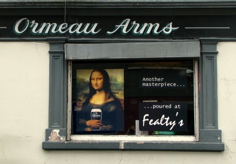A pub window display featuring the Mona Lisa holding a pint of Guinness.