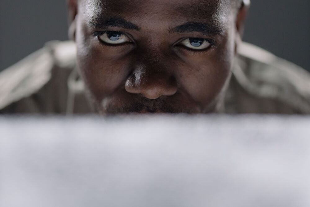 A close-up of a man’s face, focused intently, with only his eyes and part of his forehead visible above a blurred foreground.