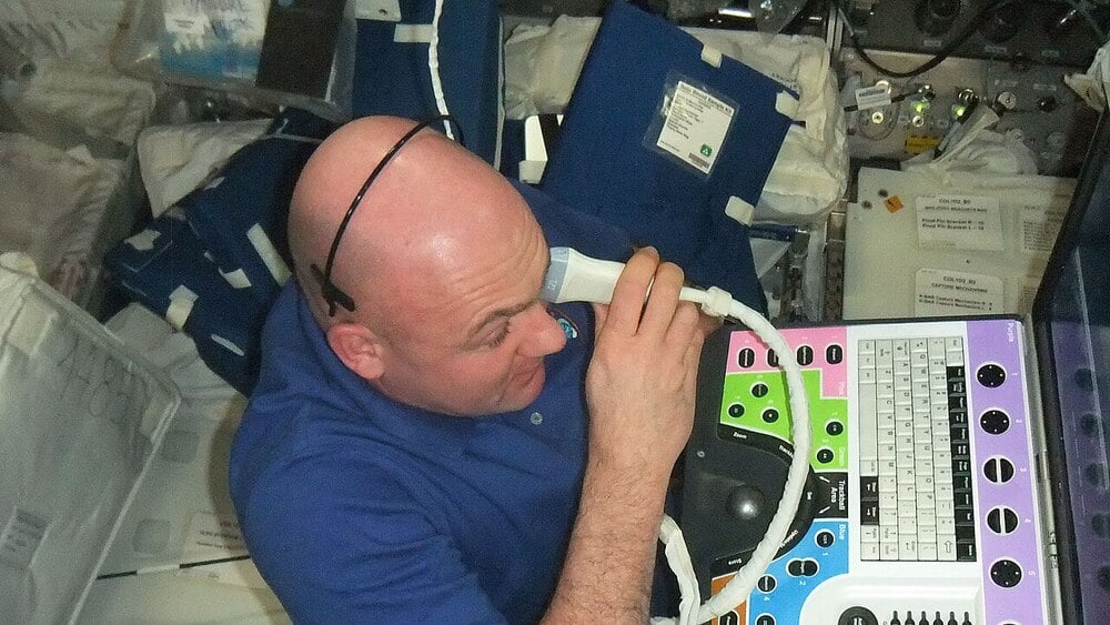An astronaut performs ultrasound eye imaging inside the International Space Station.