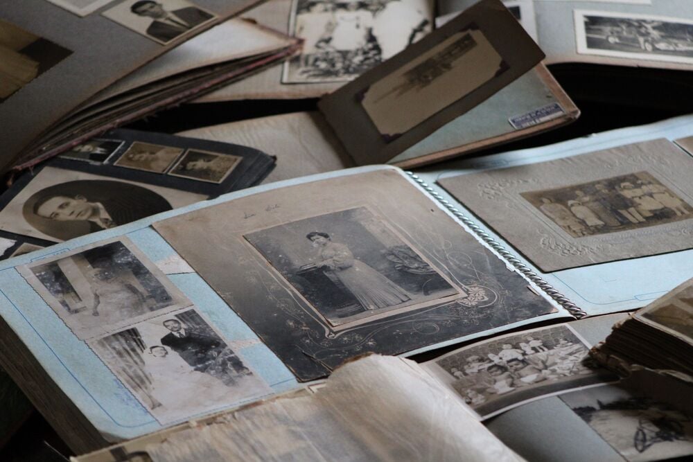 Several old photo albums are open, displaying black-and-white and sepia family photographs.