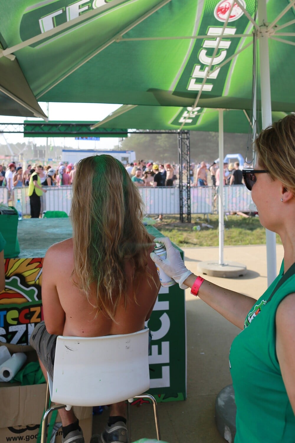A lively outdoor festival scene with visitors and tents.