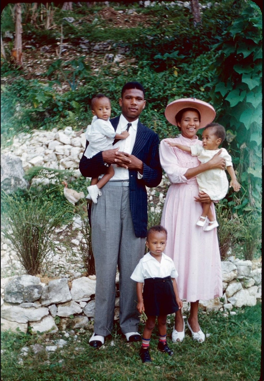 A family of five poses outdoors.