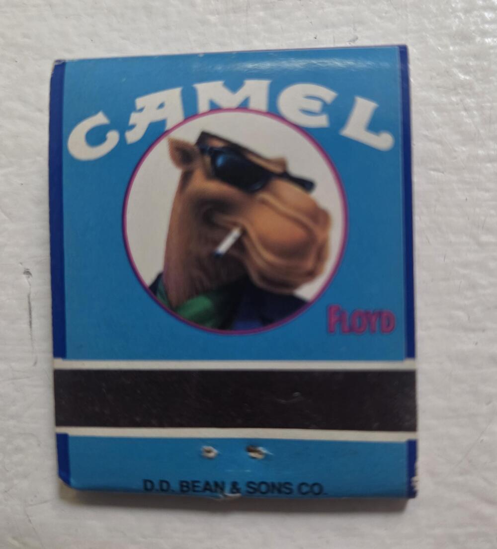 A blue Camel matchbook featuring an illustration of a camel wearing sunglasses and smoking, with the name “Floyd” to the right and “D.D. Bean & Sons Co.” at the bottom.