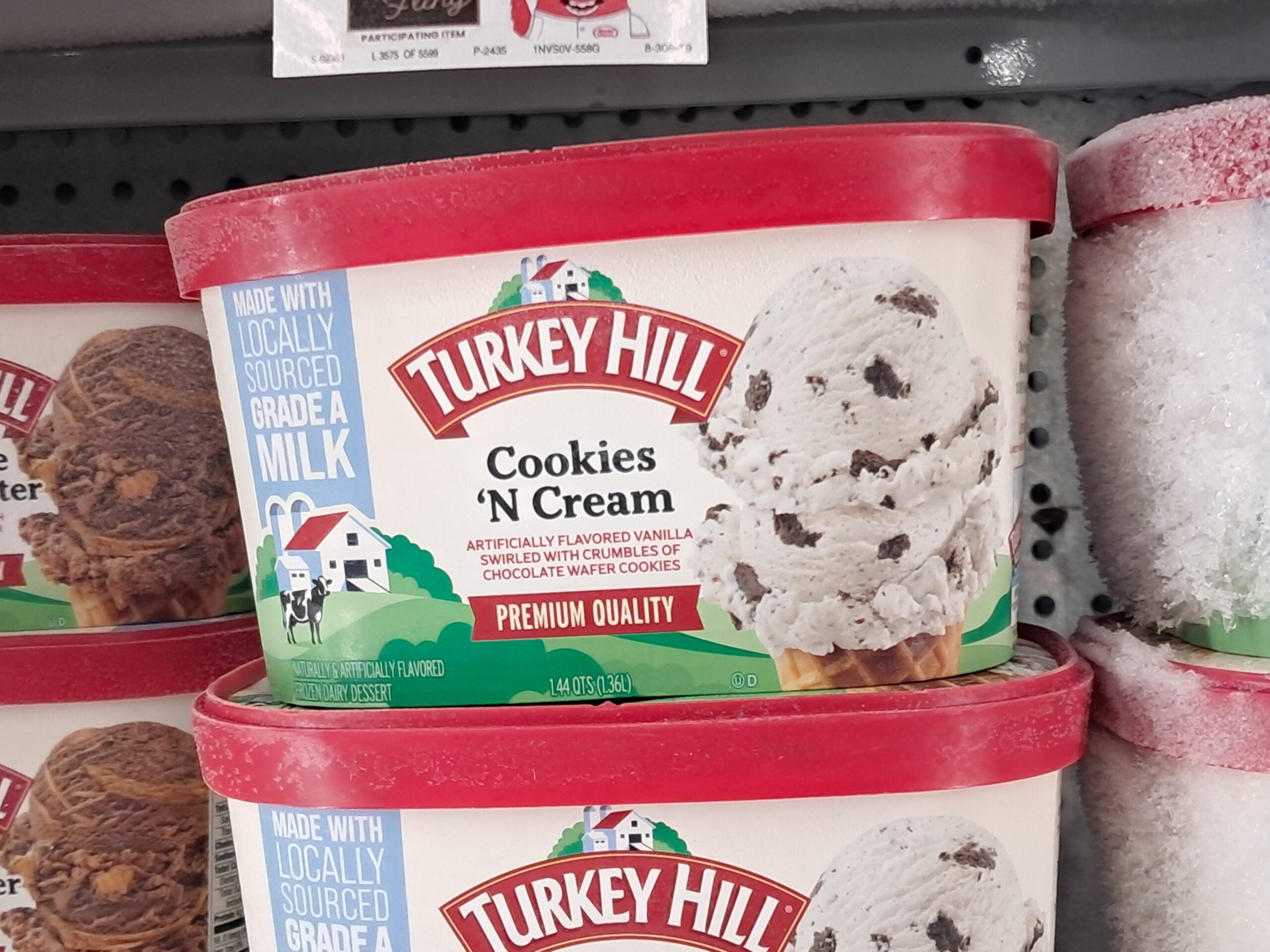 Turkey Hill Cookies 'N Cream ice cream container on a store shelf.