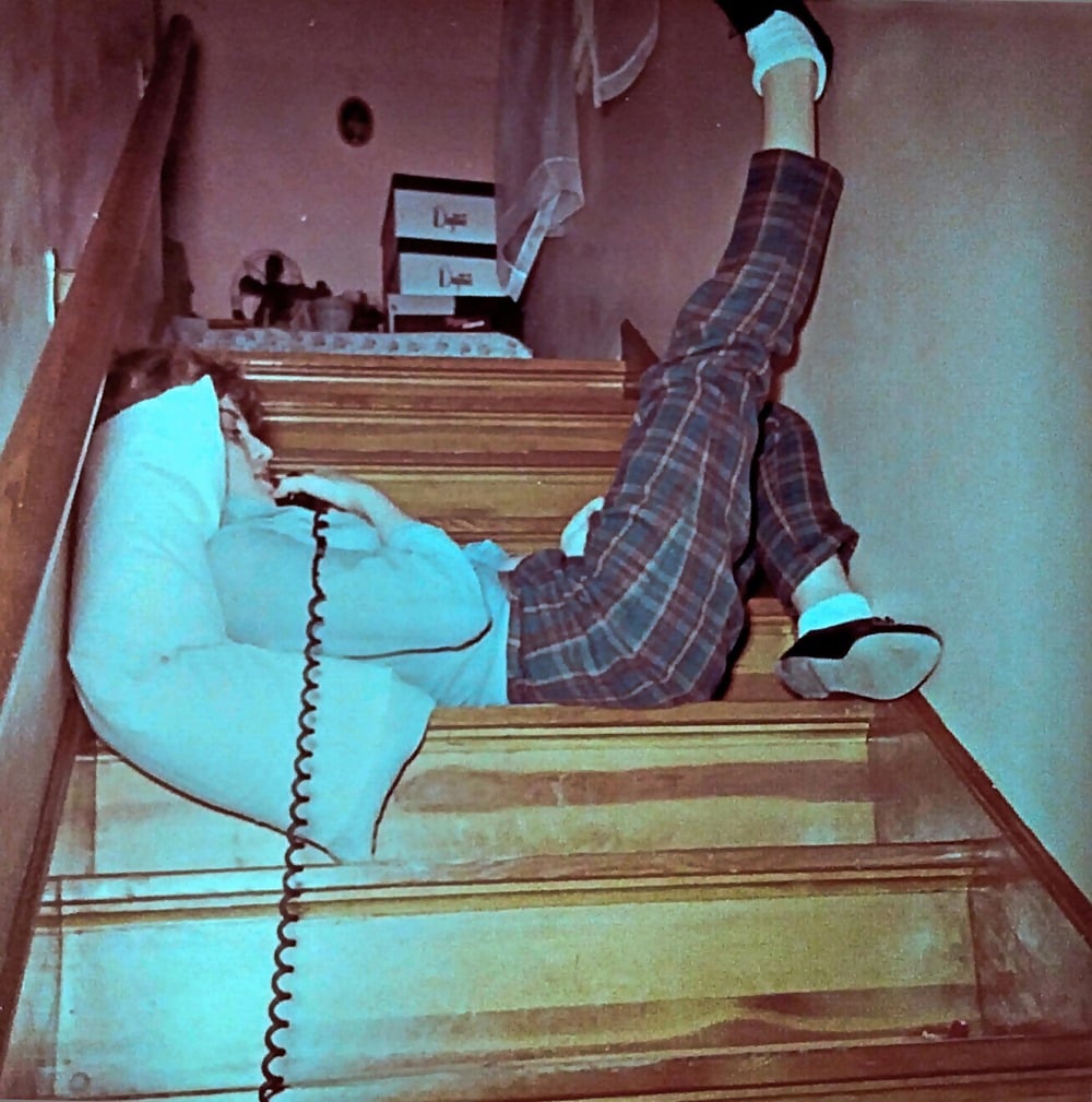 A person talks on a corded phone.