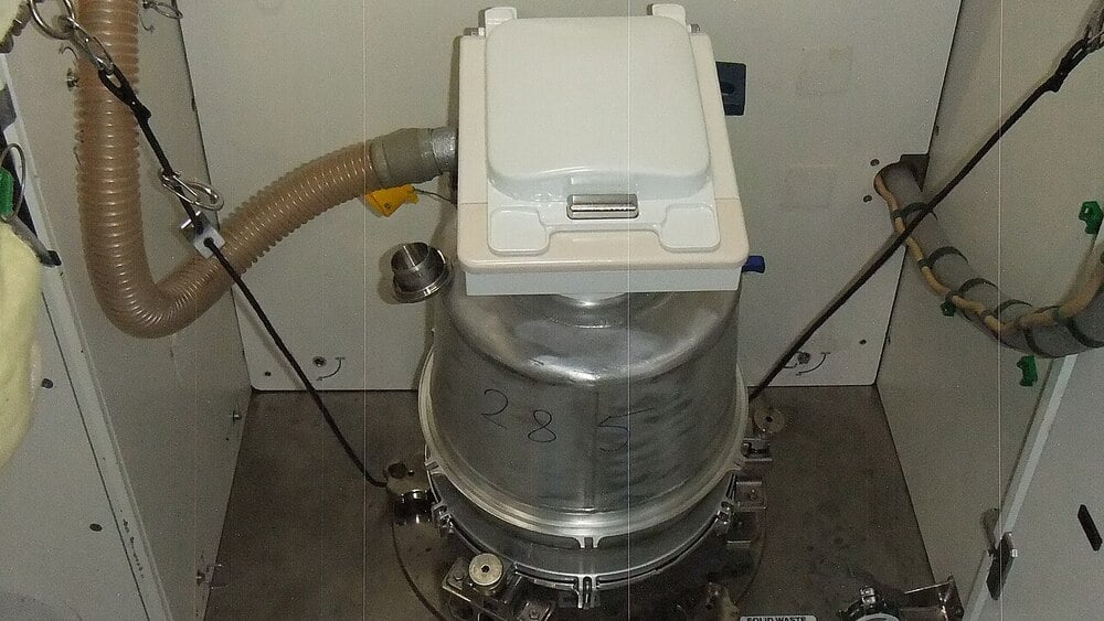 A space toilet designed for waste management aboard a spacecraft.