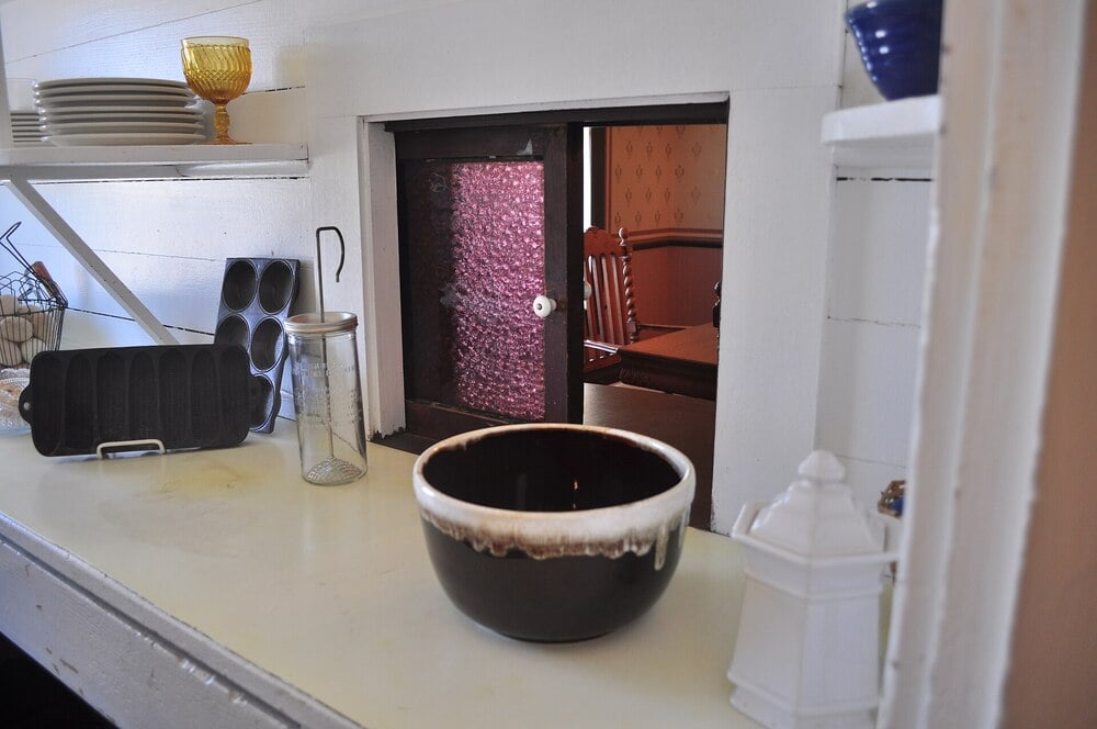 A historic pantry with a work counter and a pass-through to the dining room.