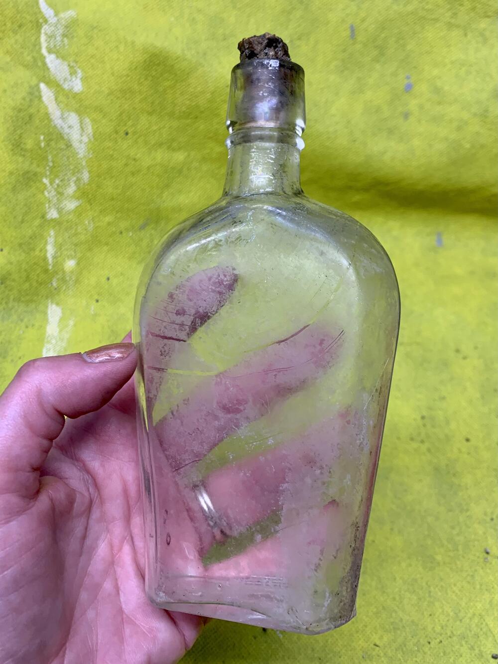 An old glass bottle with a cork stopper.