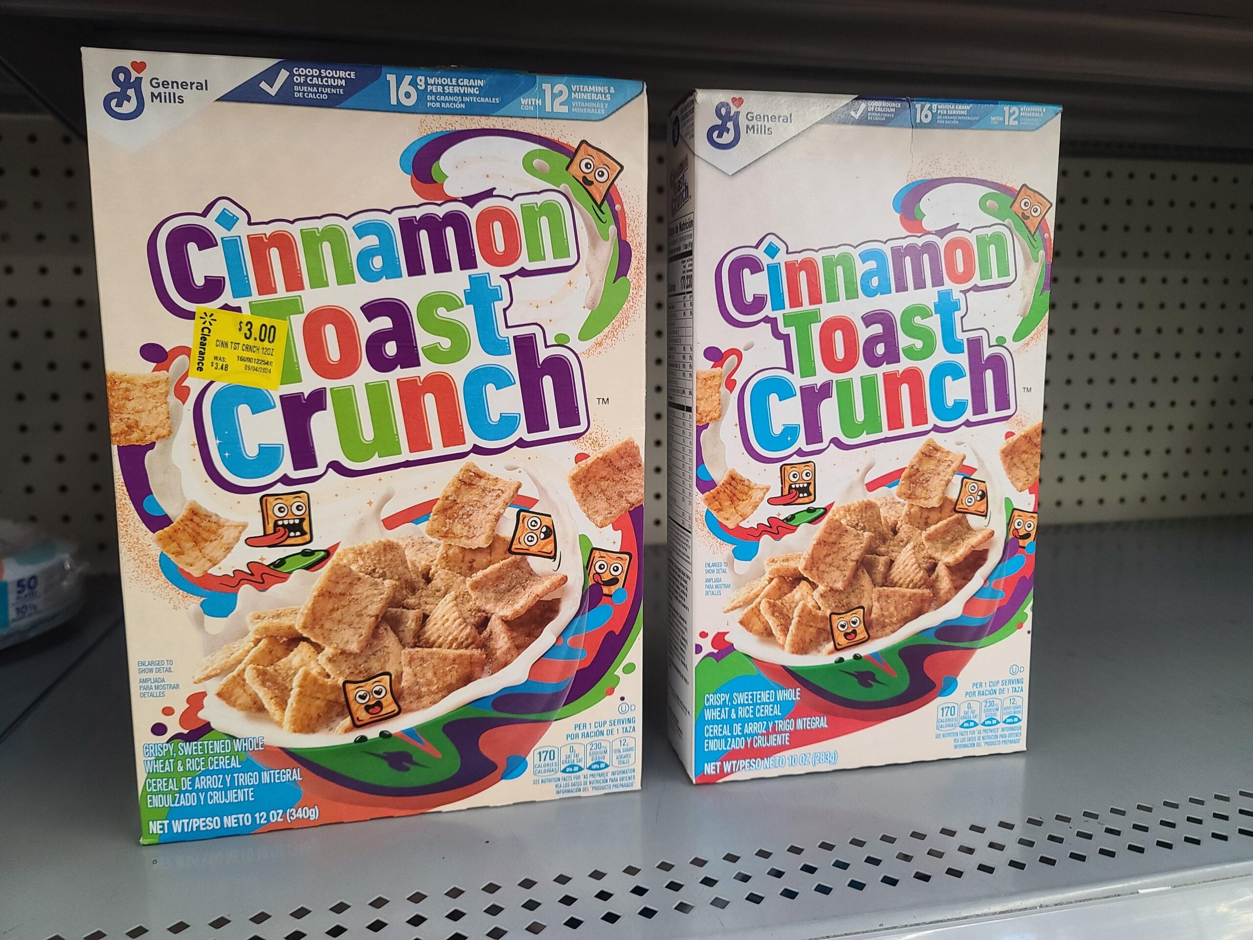 Two boxes of Cinnamon Toast Crunch cereal on a store shelf.