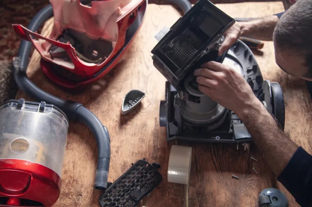 A disassembled vacuum cleaner being repaired.