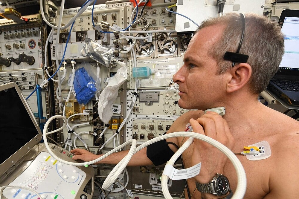 An astronaut uses medical equipment inside a space station.