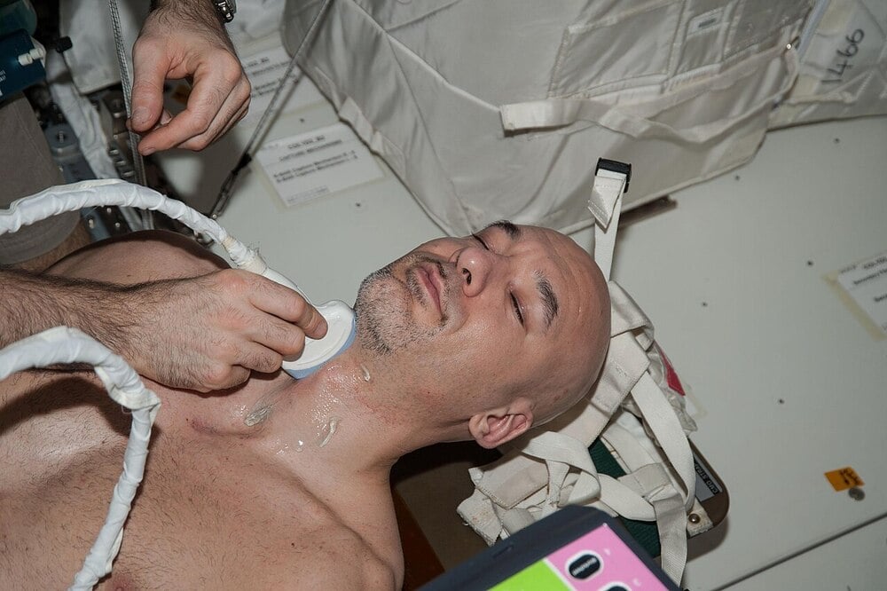 An astronaut undergoes a spinal ultrasound examination aboard a spacecraft.