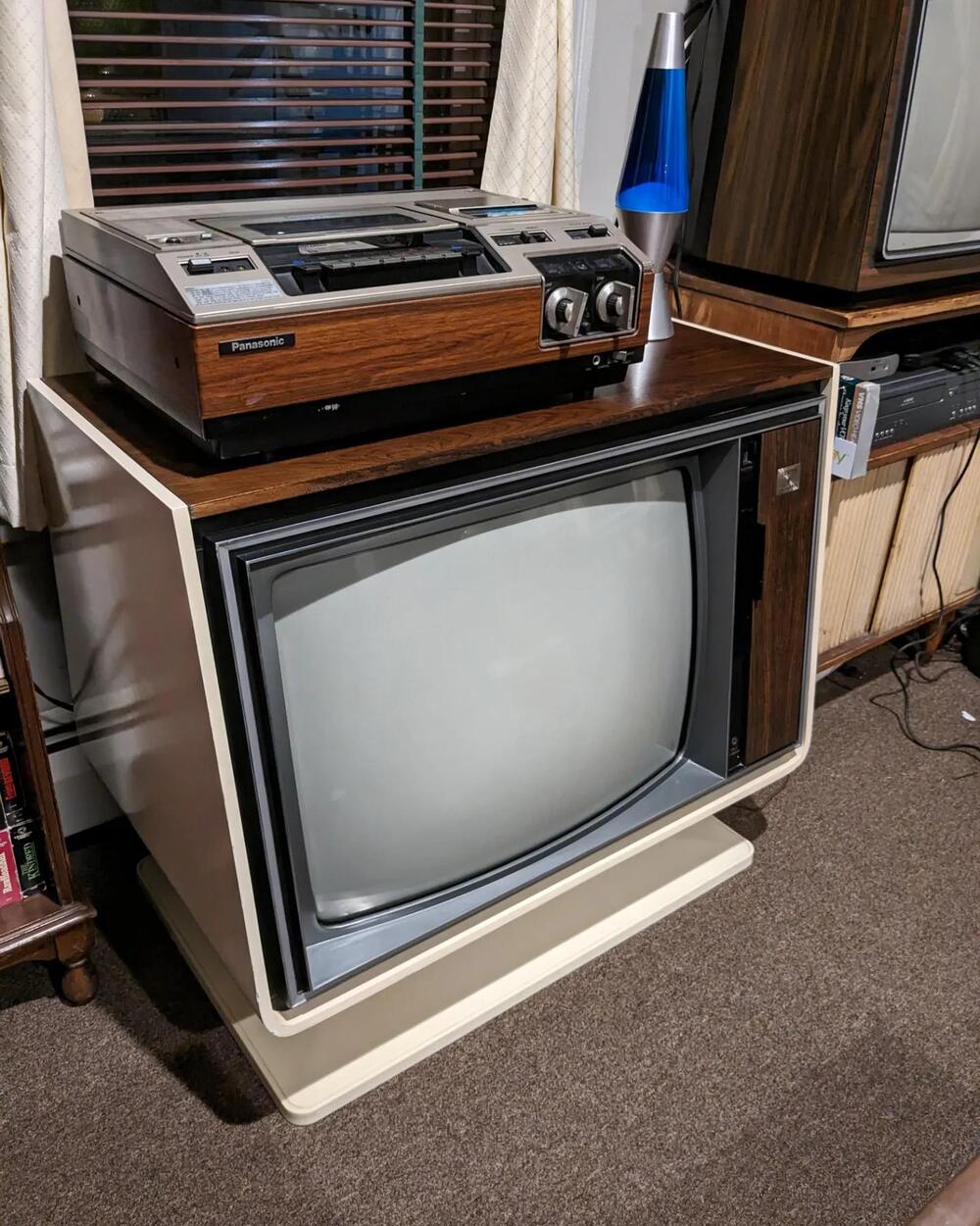 An early top-loading VCR placed on a television.