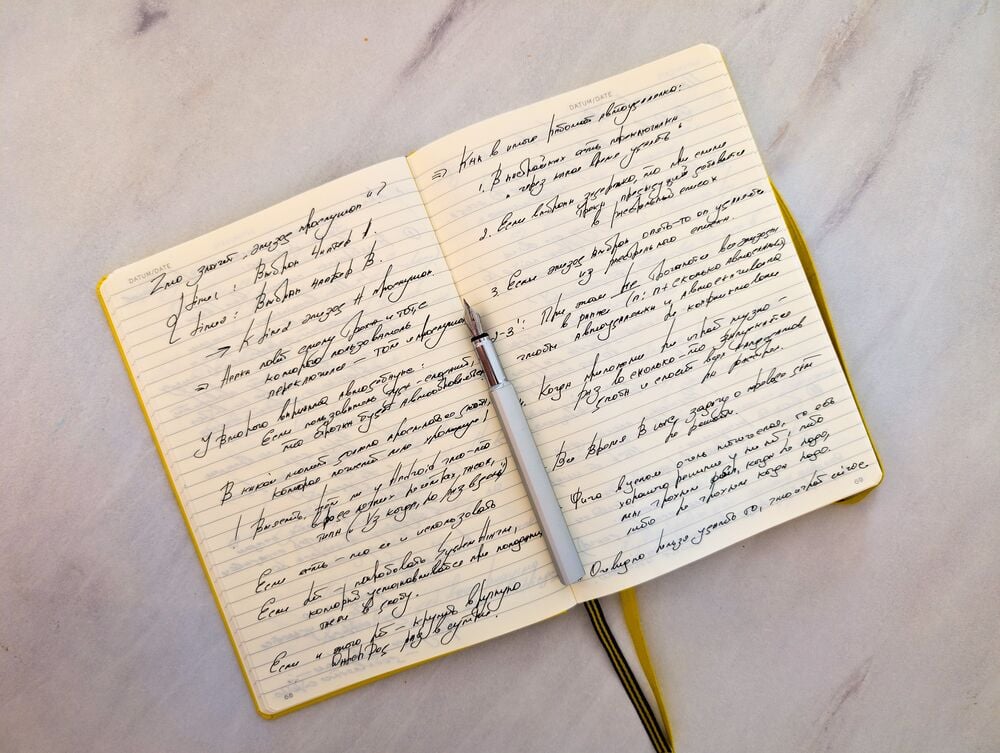 An open notebook with handwritten text on both pages, written in cursive with black ink.