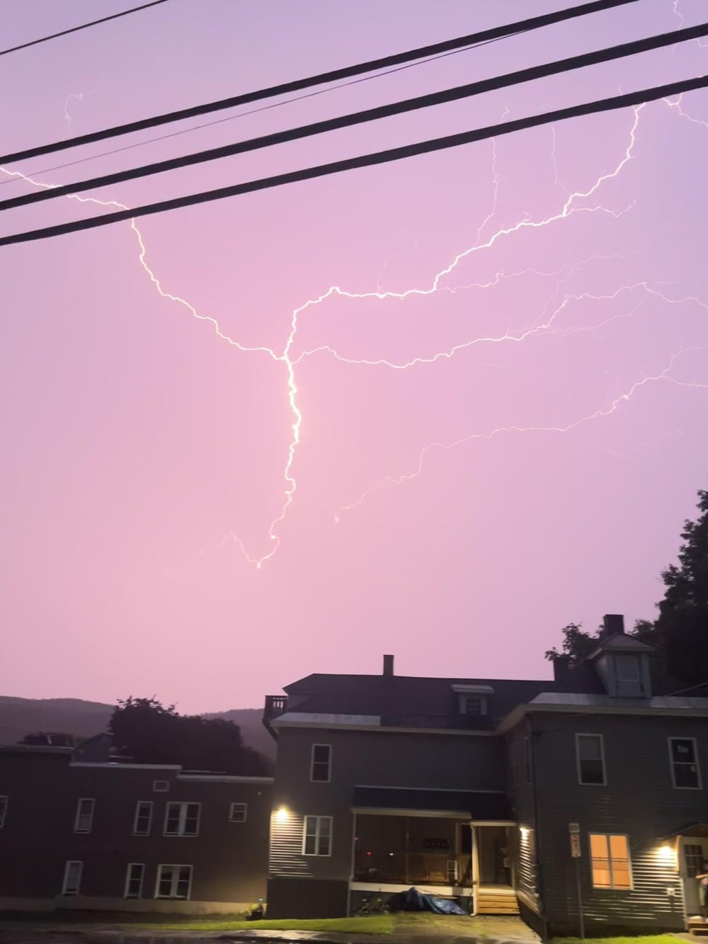 A bright lightning bolt streaks across a purple sky.