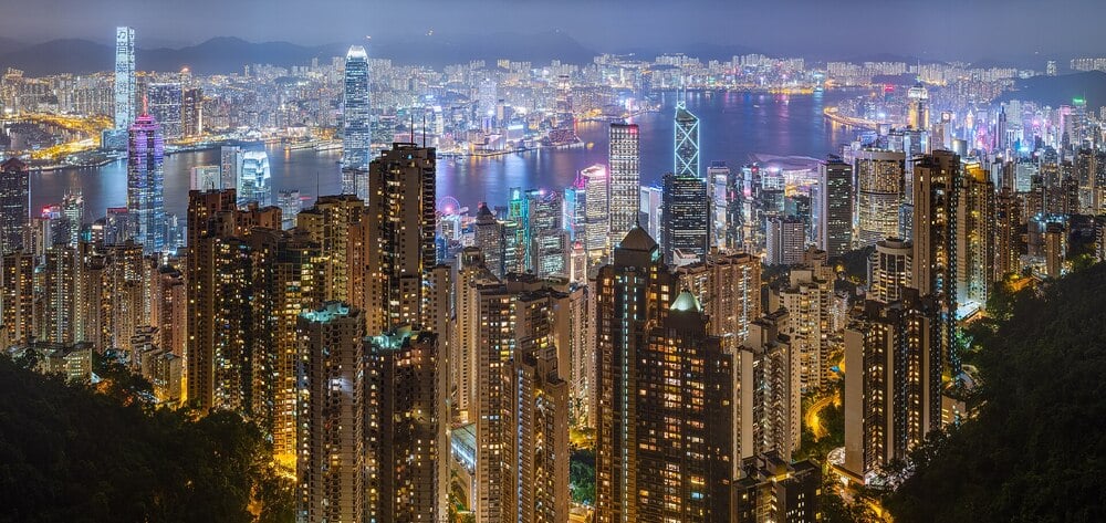 Panoramic night view of Hong Kong's dense skyline and harbor.