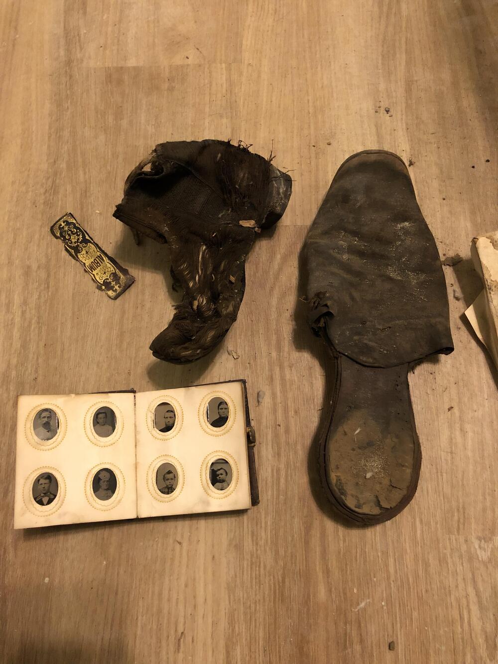 Worn shoes, a portrait album, and other personal belongings discovered during renovation.