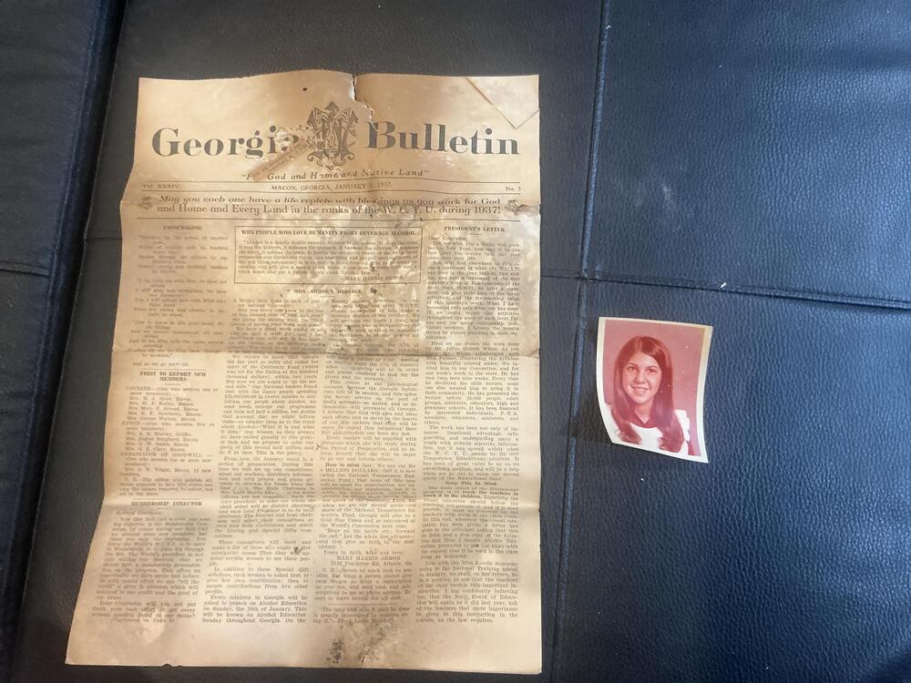 An old newspaper beside a portrait photo found inside a wall.