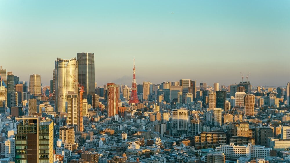 Tokyo skyline at sunset with Tokyo Tower and Mount Fuji in the distance.