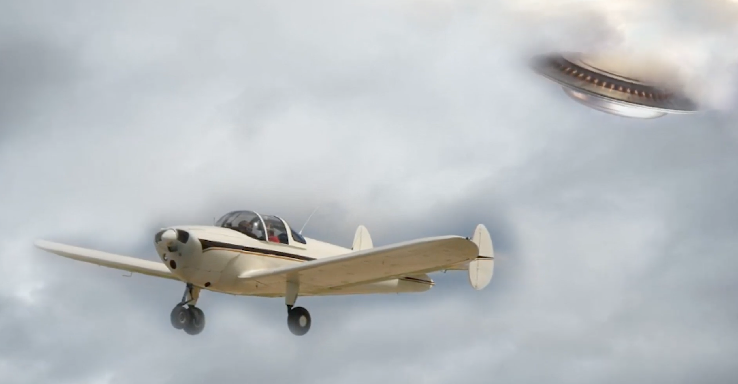 A small propeller airplane flies through cloudy skies while a metallic UFO with lights appears above it, partially obscured by clouds.