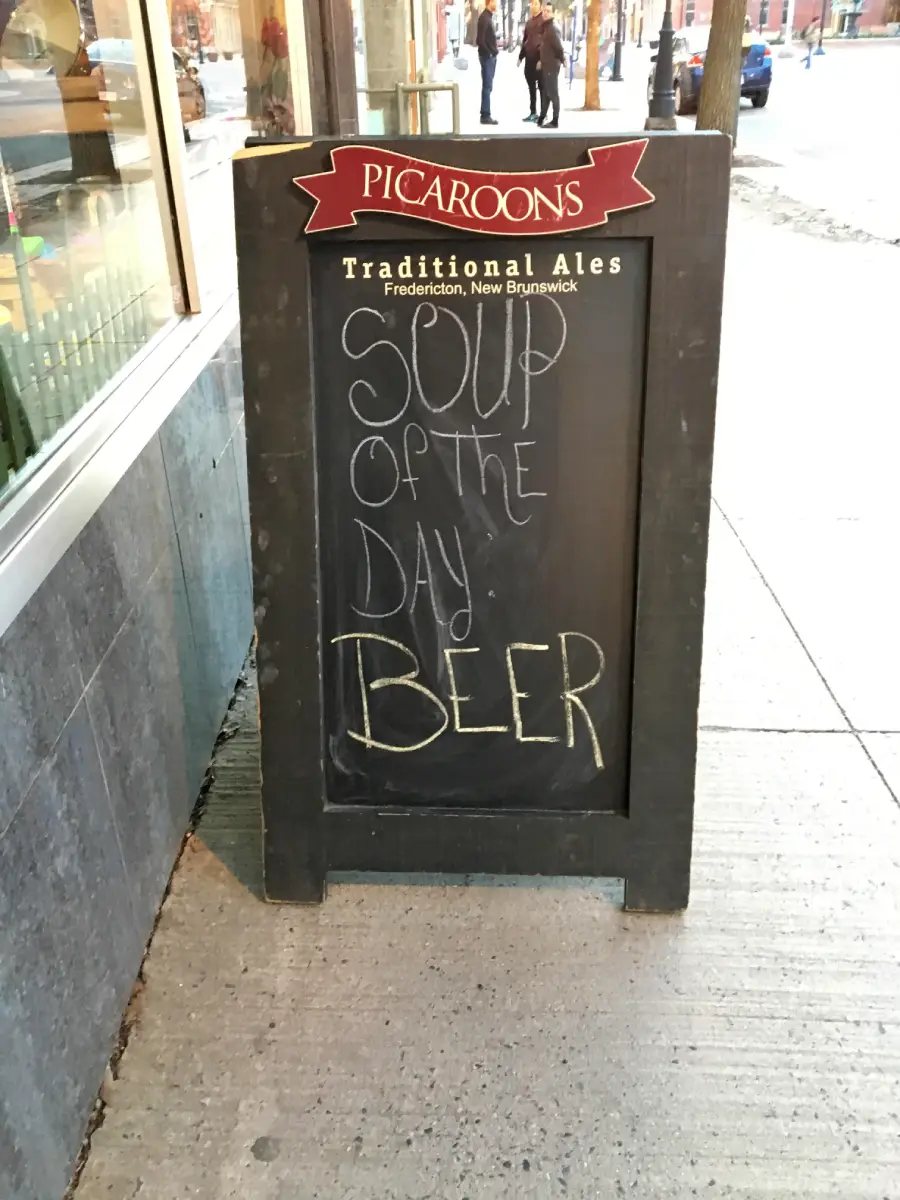 A chalkboard sign outside a pub reads: “Soup of the day: BEER.” The sign is for Picaroons Traditional Ales, located in Fredericton, New Brunswick.