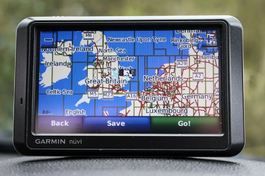 A Garmin nüvi GPS device displays a map of western Europe, highlighting Great Britain, Ireland, the Netherlands, Belgium, Germany, and surrounding areas with navigation options “Back,” “Save,” and “Go!”
