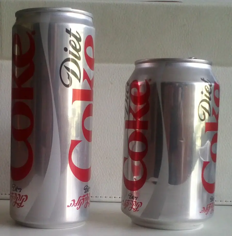 Two Diet Coke cans side by side; the can on the left is tall and slim, while the can on the right is shorter and wider. Both have similar silver and red designs.