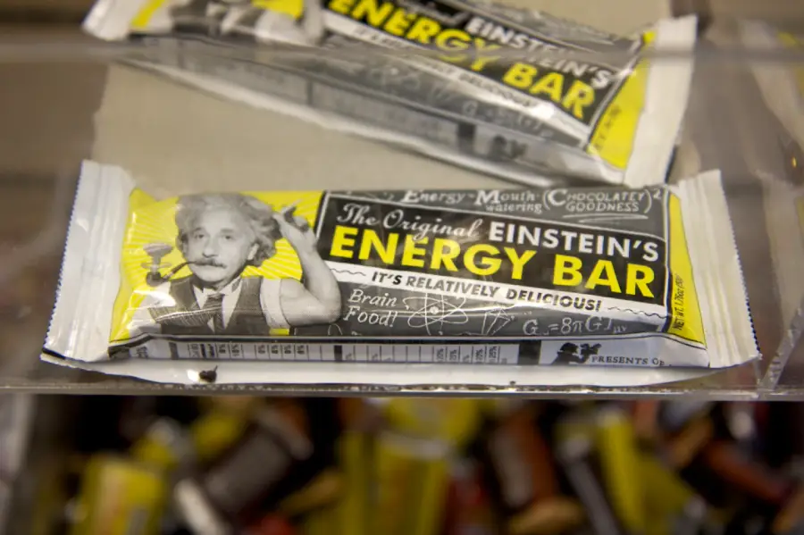 Energy bar labeled “The Original Einstein’s Energy Bar” featuring an illustration of Albert Einstein making a funny face, with text “It’s relatively delicious! Brain food!” and various playful scientific elements.